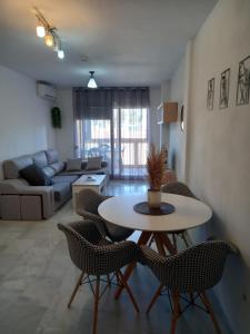 a living room with a table and chairs and a couch at Apartamento Golf in Roquetas de Mar