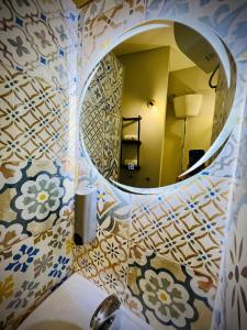 a bathroom with a round mirror and a sink at Sun Apartments in Agrigento