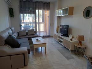 a living room with a couch and a tv at Apartamento Golf in Roquetas de Mar