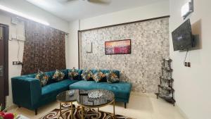 a living room with a blue couch and a table at Residential Apartment Complex El-cilo B 414 in Islamabad