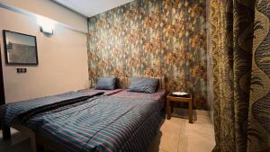 a bedroom with a bed with a large painting on the wall at Residential Apartment Complex El-cilo B 414 in Islamabad