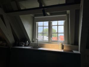 cocina con fregadero y ventana en Stadsklooster Dordt Hotel&Hostel en Dordrecht