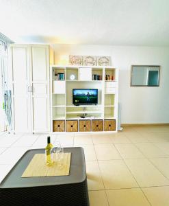 un salon avec une télévision et une table dans l'établissement Azahara Playa III, à Arona