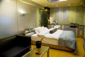 横浜市にあるグランドガーデン （大人専用）のベッドとキッチン付きのホテルルーム