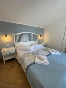 ein Schlafzimmer mit einem Bett mit zwei Handtüchern darauf in der Unterkunft STARA GAVZA - bungalows , apartments in Cres