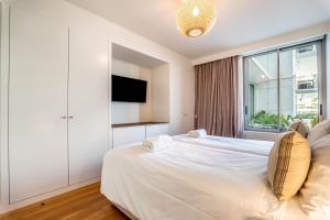 Un dormitorio blanco con una cama grande y una ventana. en Beachfront Garden & SPA - indoor and outdoor pool, en Armação de Pêra 49 fotos más