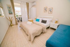 1 dormitorio con 1 cama blanca y 1 sofá azul en Apartments Lungo Mare Ulcinj, en Ulcinj