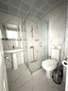 a bathroom with a shower and a toilet and a sink at Navy Hotel in Marmaris