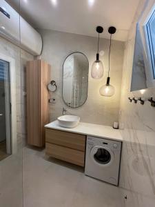 ein Badezimmer mit einem Waschbecken und einer Waschmaschine in der Unterkunft STARA GAVZA - bungalows , apartments in Cres