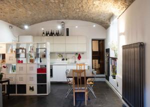 Casa Bia في بورليتسا: مطبخ مع خزائن بيضاء وطاولة وكراسي