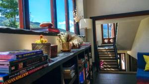 a room with a book shelf with books and a window at The Postcard Dewa, Thimphu, Bhutan in Thimphu