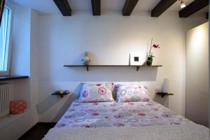 Casa Bia في بورليتسا: غرفة نوم مع سرير وملاءات ووسائد وردية