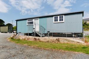 ein blaues Haus mit einem Zaun davor in der Unterkunft Mount View Overnight Accommodation in Penzance