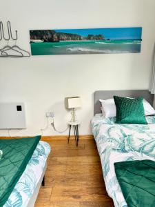 1 dormitorio con 2 camas y un cuadro en la pared en Cockleshell Cottage en Falmouth
