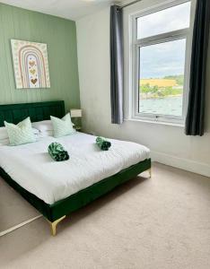 1 dormitorio con 1 cama grande y ventana en Cockleshell Cottage en Falmouth