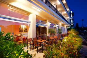 a restaurant with tables and chairs on a patio at Hotel Dalia in Corfu Town