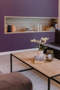 a coffee table in a living room with a purple wall at Impresamente Art Hotel in Sofia +24 photos