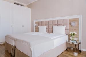 Un dormitorio blanco con una cama grande y una mesa en Impresamente Art Hotel en Sofía