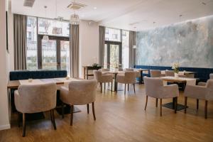 uma sala de jantar com mesas e cadeiras e um quadro grande em Impresamente Art Hotel em Sófia