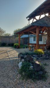 a wooden pavilion with a picnic table in a yard at Anna Apartman in Maroslele