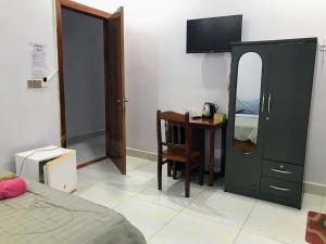 a bedroom with a desk and a mirror and a bed at Orchid 101 in Kampot