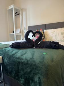Dos cisnes negros están sentados en una cama. en 2 Bed ground floor apartment, sleeps 4 with free parking, en Harrogate