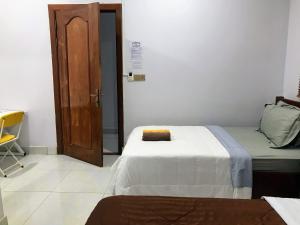 sypialnia z łóżkiem i drewnianymi drzwiami w obiekcie Orchid 101 w mieście Kâmpôt
