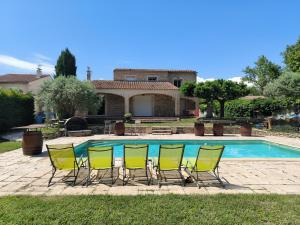 un grupo de sillas sentadas frente a una piscina en Maison proche Dentelles Ventoux et Avignon, en Sarrians