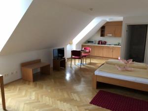 a attic room with a bed and a kitchen at Gästehaus im Priesterseminar Salzburg in Salzburg