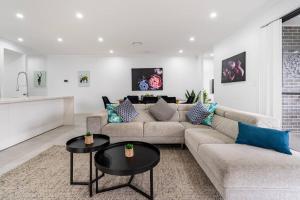 Una sala de estar con un sofá y dos mesas. en Neat 4 Bedroom in Catherine Fields, en Narellan