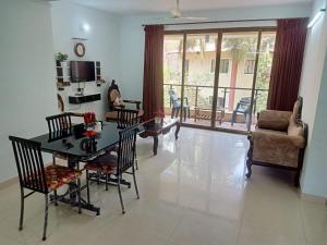 a living room with a table and chairs and a couch at Palolem garden estate in Canacona