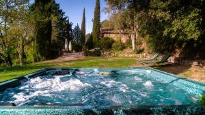 Can Serola في Sales del Llierca: حوض استحمام ساخن مع ماء في الفناء