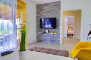 a living room with a tv on a brick wall at Villa Bubinka in Bihać
