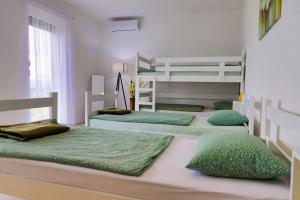 1 Schlafzimmer mit 2 Etagenbetten und grünen Kissen in der Unterkunft Villa Bubinka in Bihać