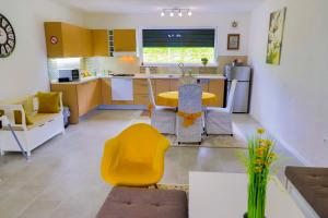 Il comprend une cuisine et un salon avec une chaise jaune et une table. dans l'établissement Villa Bubinka, à Bihać