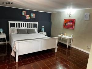 1 Schlafzimmer mit einem weißen Bett und 2 Tischen in der Unterkunft Corte dei medici - Palace in Catania