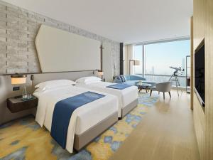 深圳Mandarin Oriental, Shenzhen的一间有两张床和一间客厅的酒店房间