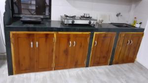 uma cozinha com um lavatório e armários de madeira em Tembewadda house em Canacona