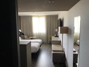 a hotel room with two beds and a window at AC Hotel by Marriott Marseille Prado Vélodrome in Marseille