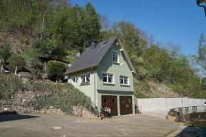 贝尔恩卡斯特尔-库斯Ferienhaus mit Whirlpool und Sauna的停车场里有车库的温室