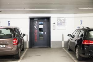 
a car parked in front of a building with a door open at IntercityHotel Dresden in Dresden
