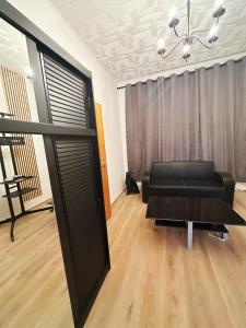 ein Wohnzimmer mit einem schwarzen Sofa und einem Tisch in der Unterkunft 2 Schlafenzimmer 5 Betten in Duisburg