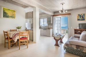 a kitchen and living room with a table and a couch at la casa di zia Anna Agia Efimia village in Ayia Evfimia