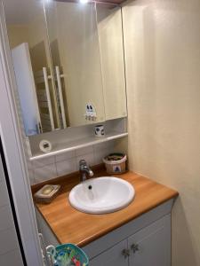a bathroom with a sink and a mirror at La parenthèse cabourgeaise in Cabourg