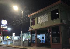 un edificio en una calle por la noche con un semáforo en Junzi en Ceiba