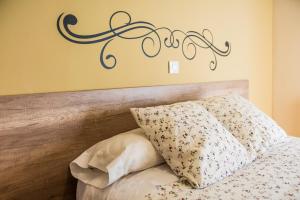 Hostal La Pastora في كانديليدا: غرفة نوم مع سرير مع علامة على الحائط