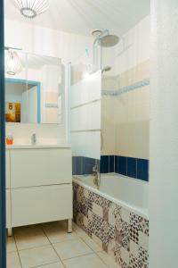 a bathroom with a tub and a sink and a mirror at maison 300m mer à Brétignolles-sur-Mer (La Parée)- Calme in Brétignolles-sur-Mer