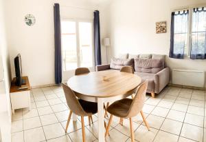 a living room with a table and a couch at maison 300m mer à Brétignolles-sur-Mer (La Parée)- Calme in Brétignolles-sur-Mer +9 photos