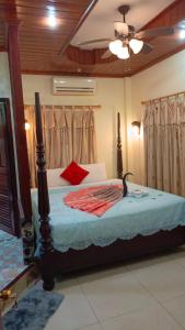 a bedroom with a bed with blue sheets and red pillows at Sakura Wood House in Luang Prabang