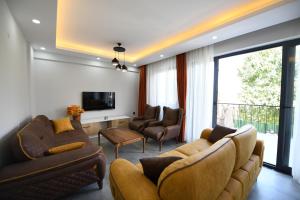 a living room with two couches and a tv at Villa Bağ Tepesi in Fethiye